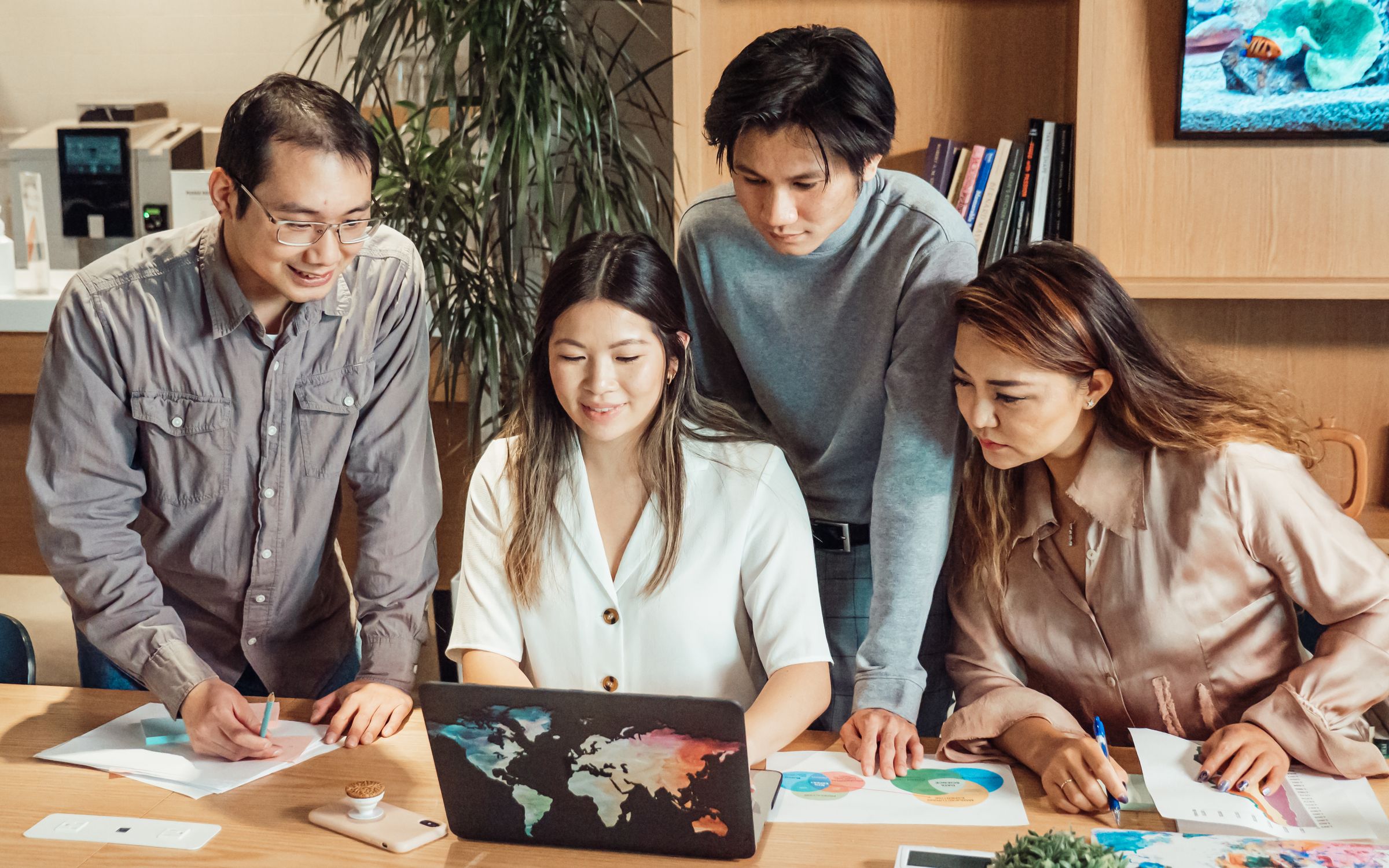 A team reviewing employee data together on a laptop in a modern office